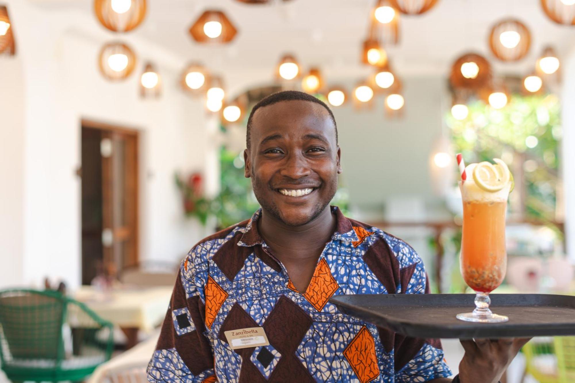 Zanzibella Hotel & Spa Kiwengwa  Exterior foto A waiter at the Serena Hotel in Kampala, Uganda